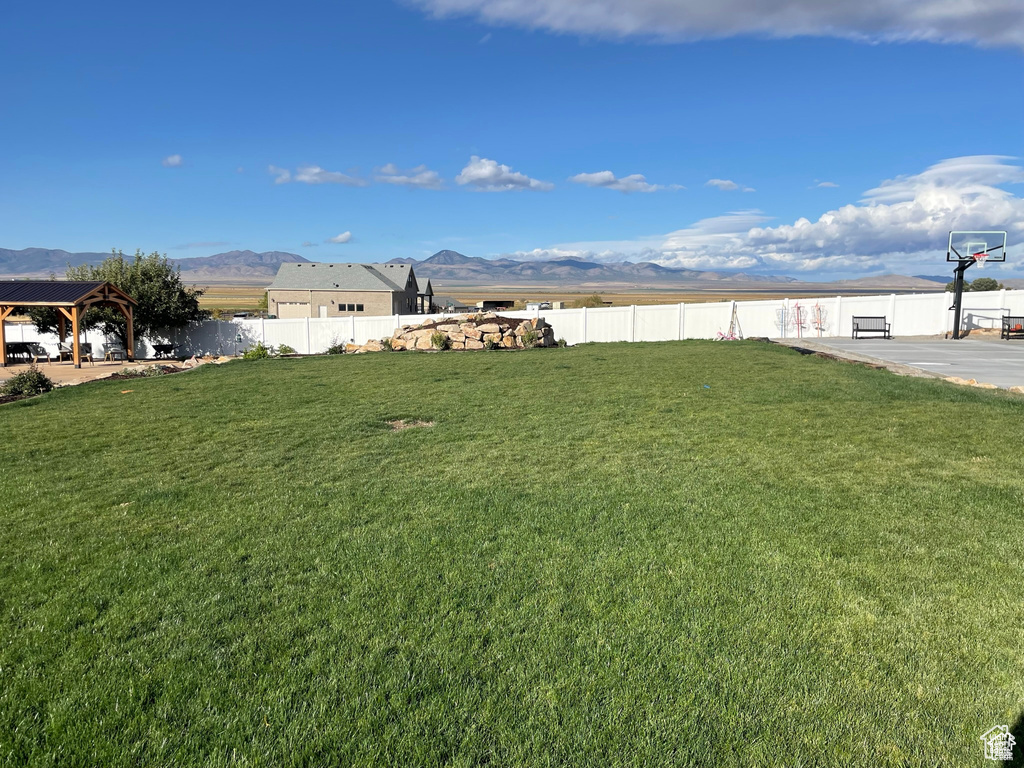 View of yard with basketball court, a gazebo, and a mountain view