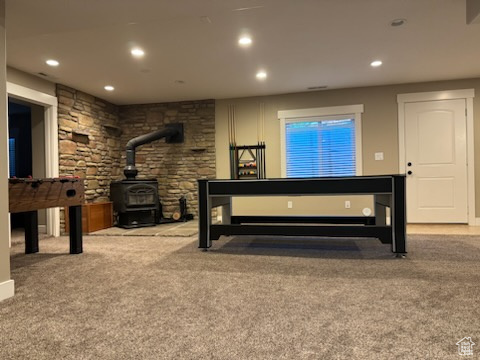 Carpeted bedroom with a wood stove and recessed lighting