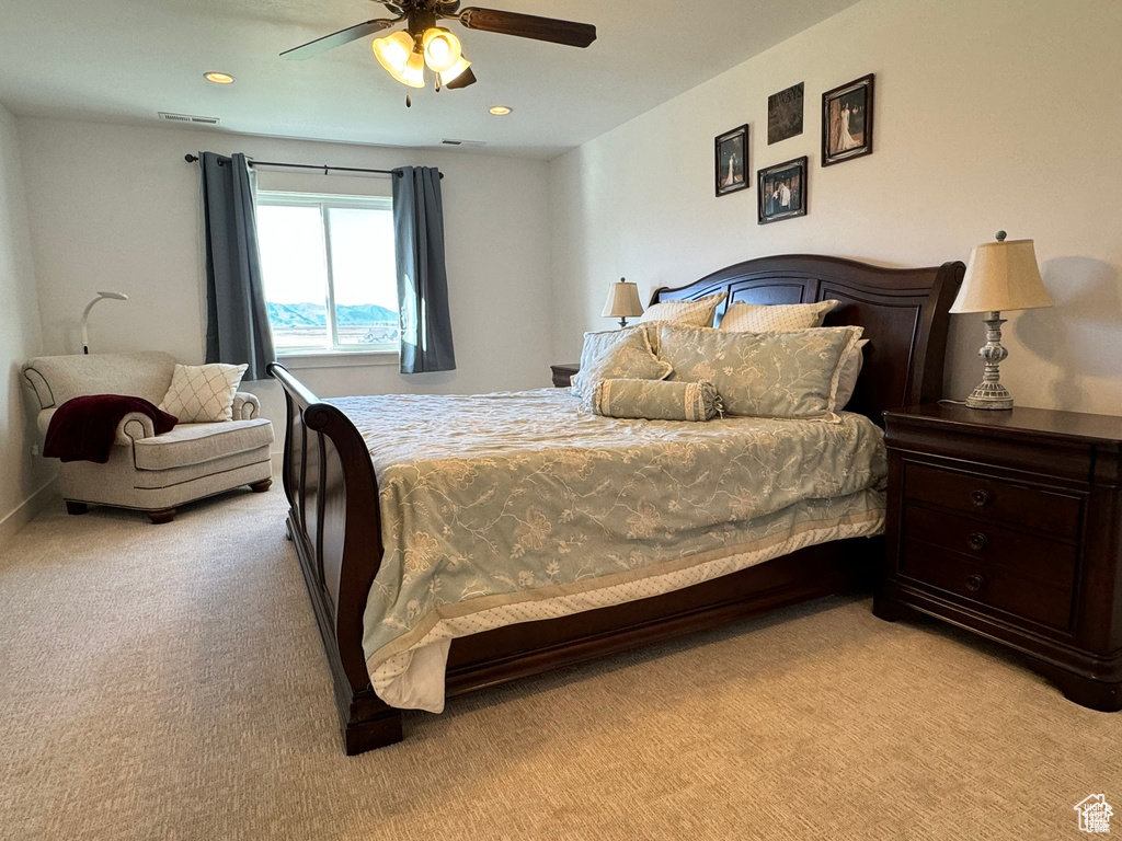 Bedroom with light colored carpet and ceiling fan
