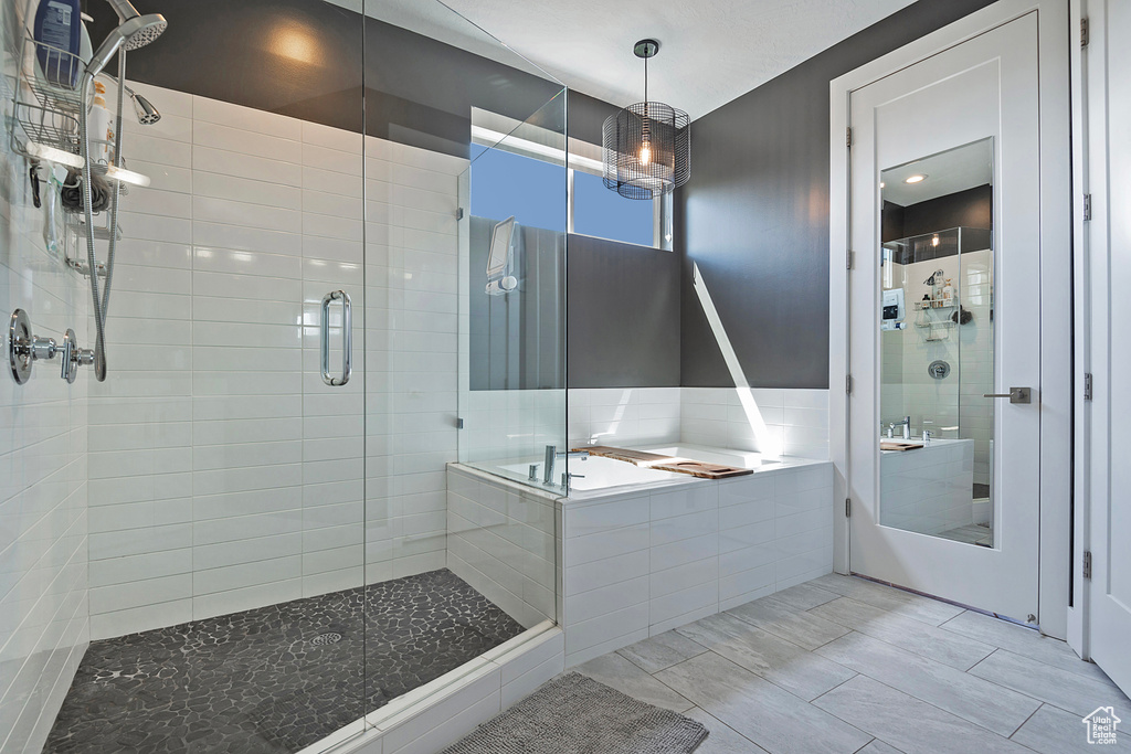 Bathroom with a stall shower, a bath, and tile patterned floors