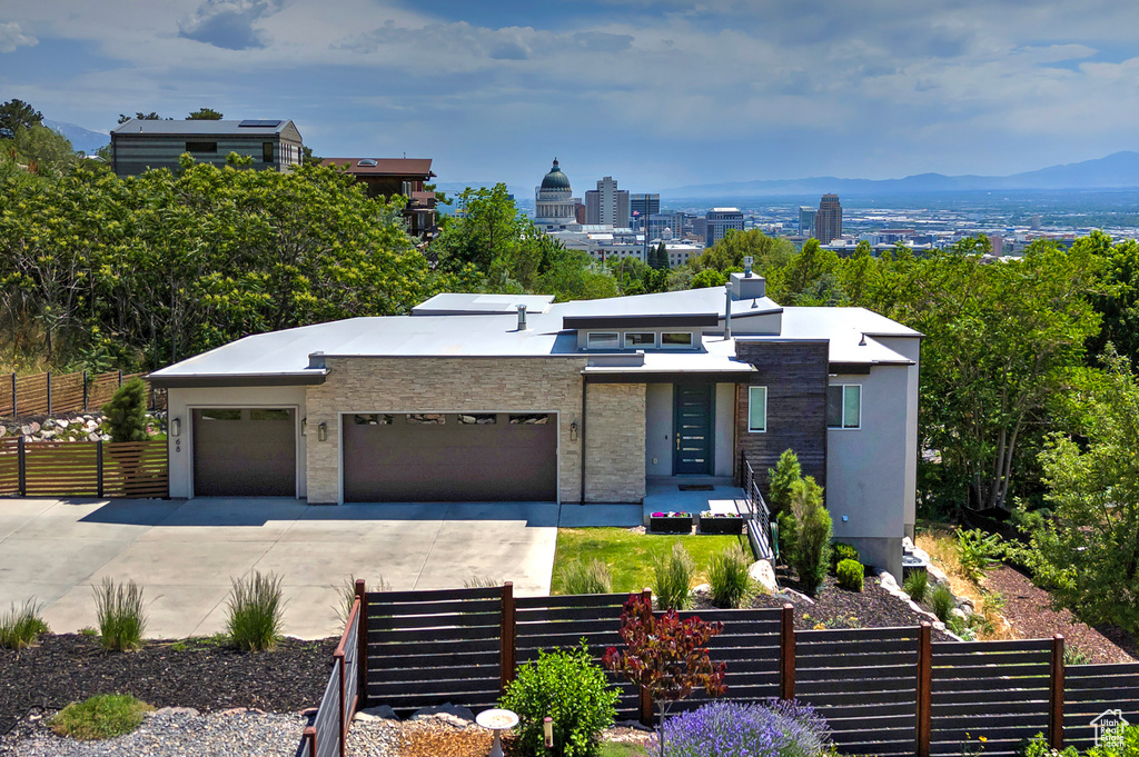 Modern home with an attached garage, concrete driveway, and stucco siding