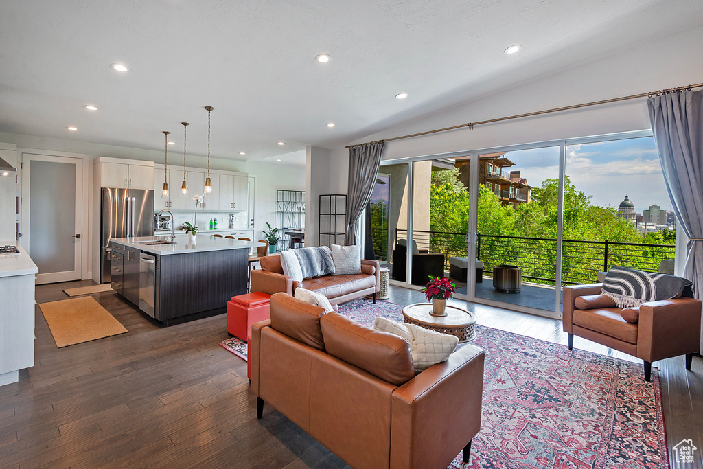 Living area featuring dark wood-style flooring, recessed lighting, and vaulted ceiling