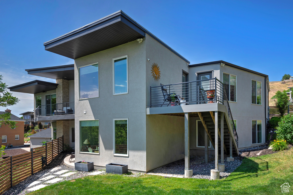 Back of house with stucco siding and stairway