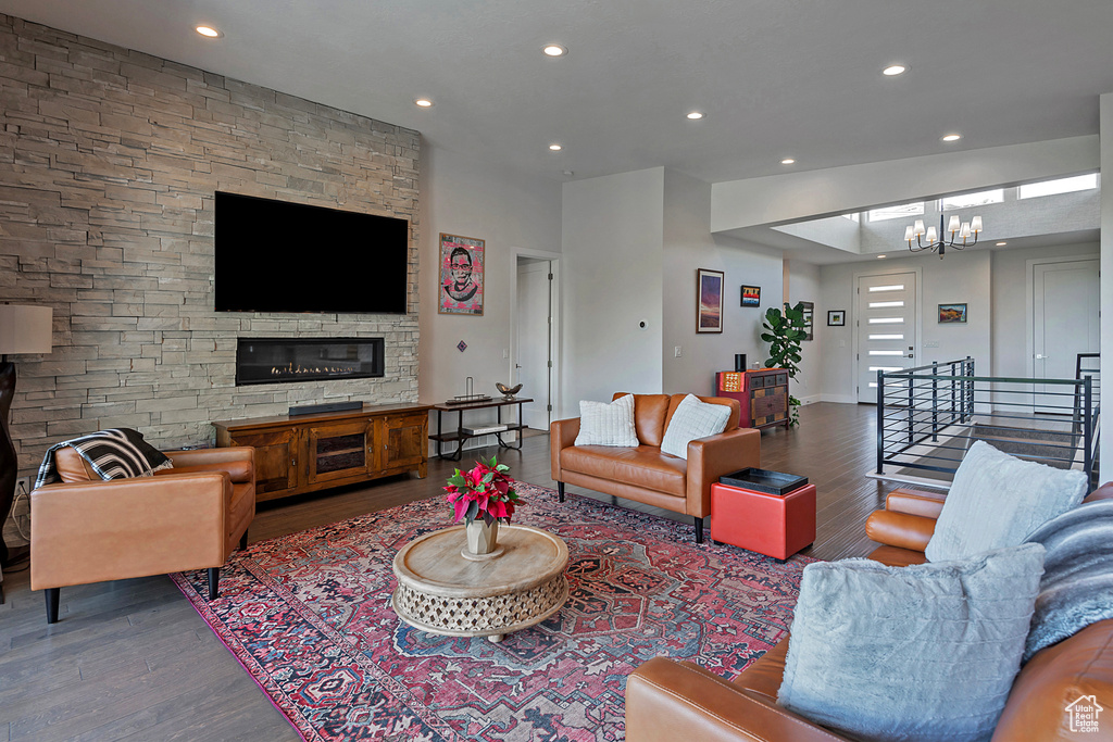 Living room with wood finished floors, recessed lighting, a chandelier, and stairs