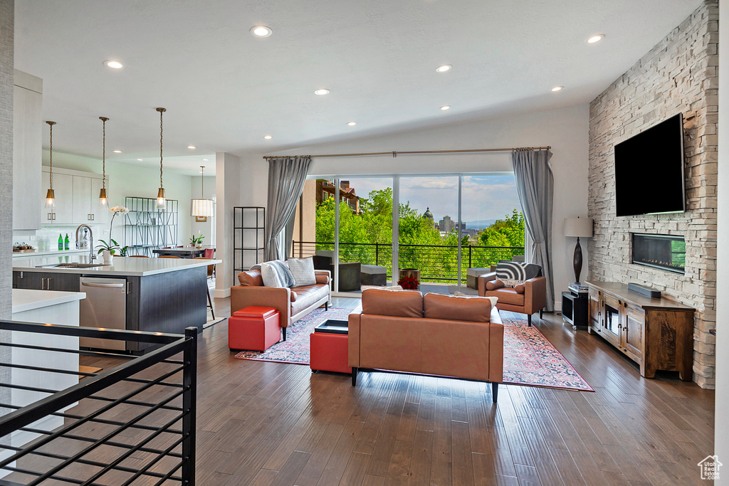 Living room featuring dark wood-type flooring, recessed lighting, and a fireplace