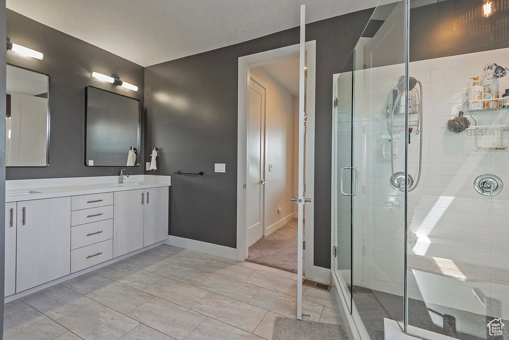 Full bathroom with double vanity and a stall shower