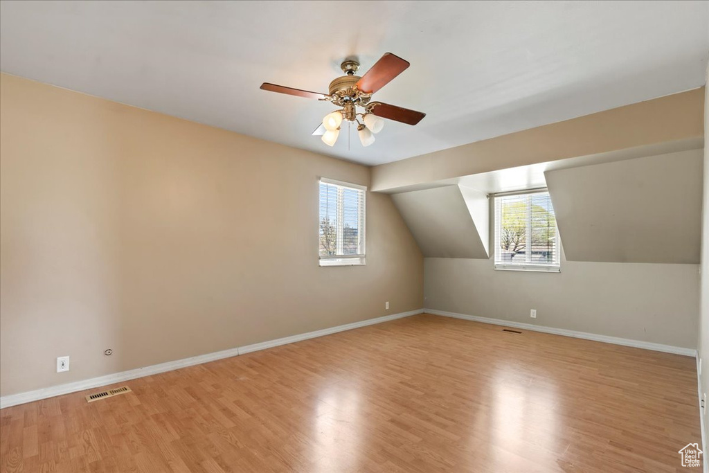 Bonus room with light wood finished floors and ceiling fan