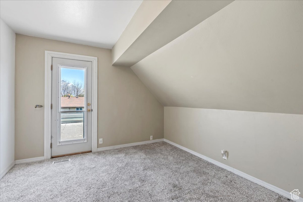 Additional living space with carpet and lofted ceiling