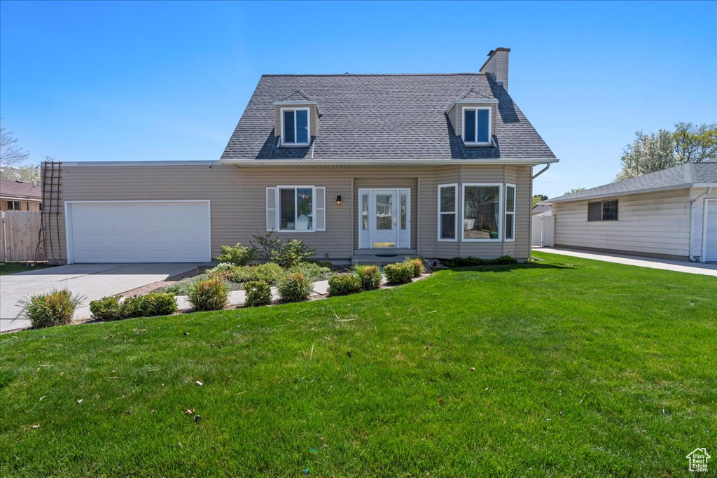 Cape cod home with concrete driveway, a garage, roof with shingles, and a chimney