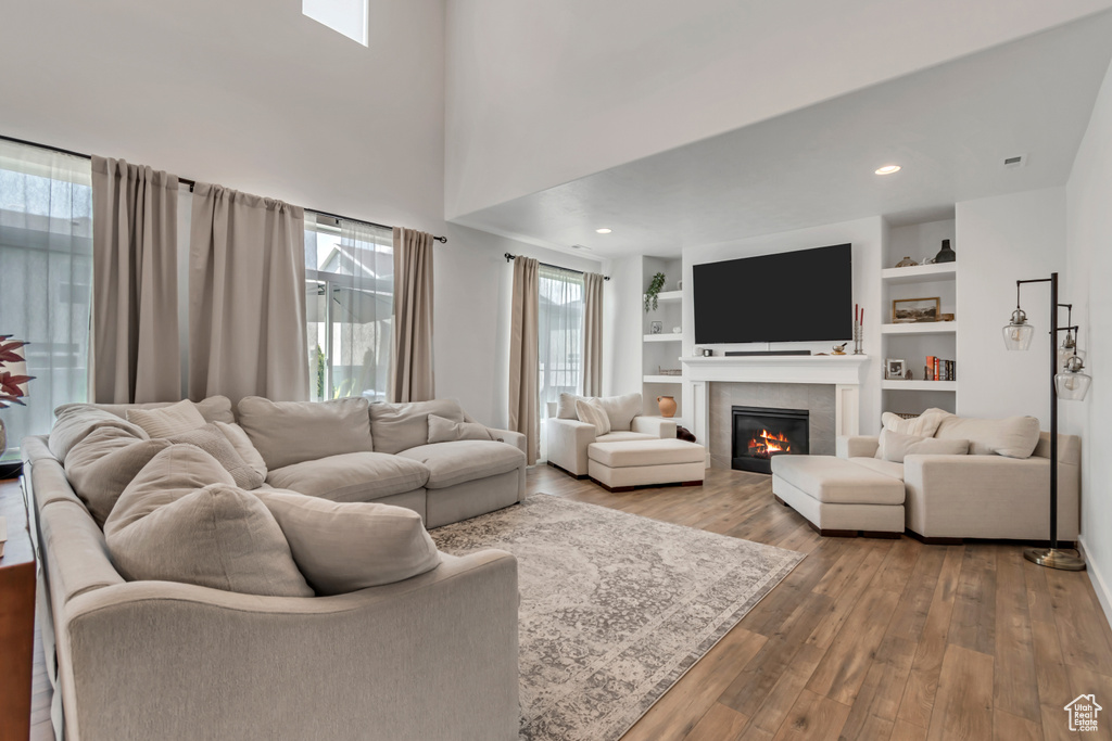 Living room featuring a tiled fireplace and wood finished floors