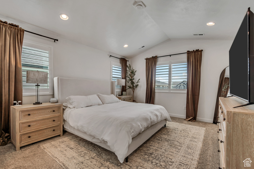 Bedroom featuring lofted ceiling, light colored carpet, arched walkways, and recessed lighting