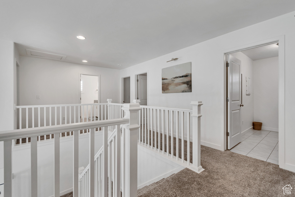 Hallway featuring an upstairs landing, recessed lighting, and carpet flooring