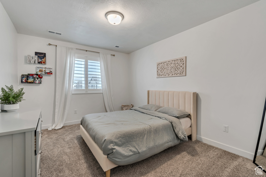 Bedroom with light colored carpet and baseboards