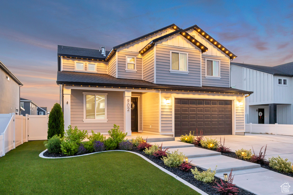 View of front of property with driveway, a garage, board and batten siding, and a shingled roof