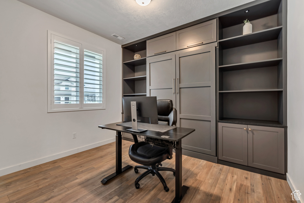 Office space with wood finished floors and a textured ceiling