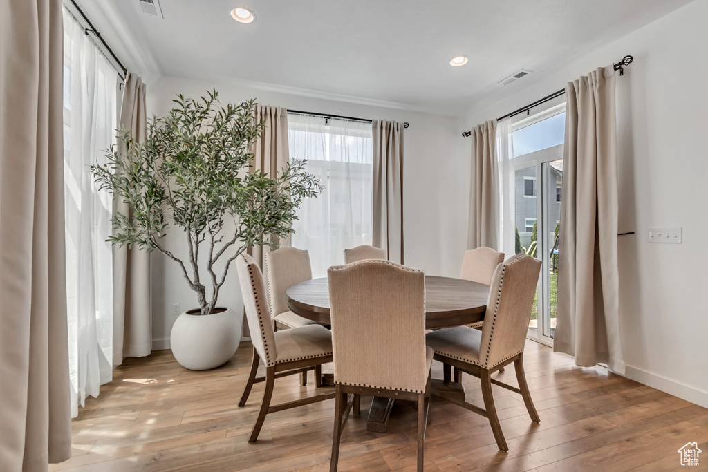 Dining area with plenty of natural light, light wood-style floors, and recessed lighting
