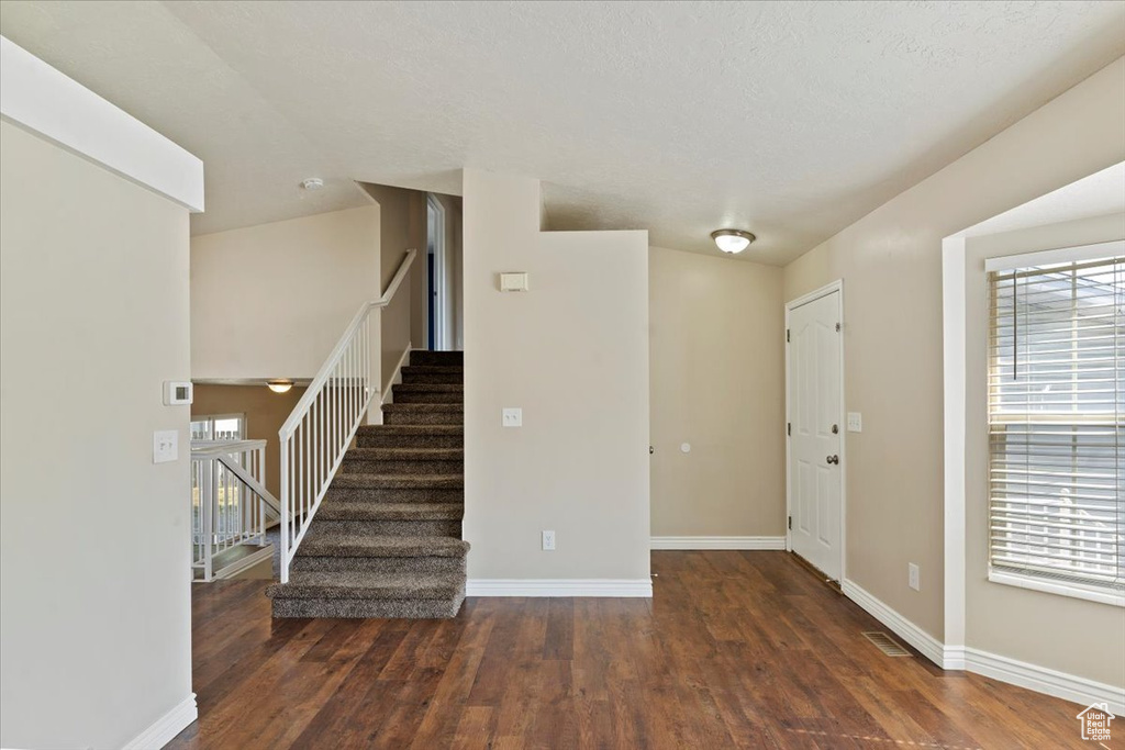 Foyer featuring stairs and wood finished floors