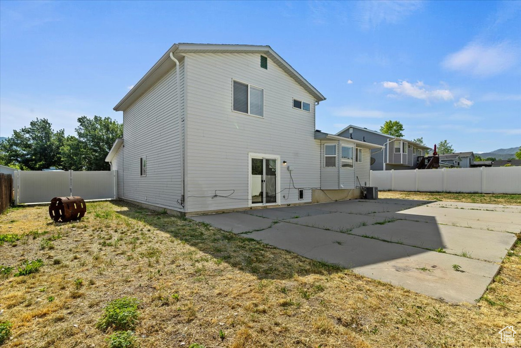 Rear view of property with a patio and a fenced backyard
