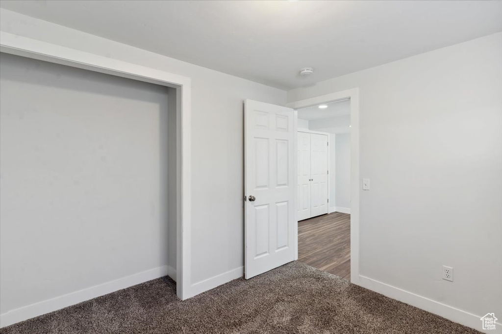 Unfurnished bedroom with dark colored carpet and recessed lighting