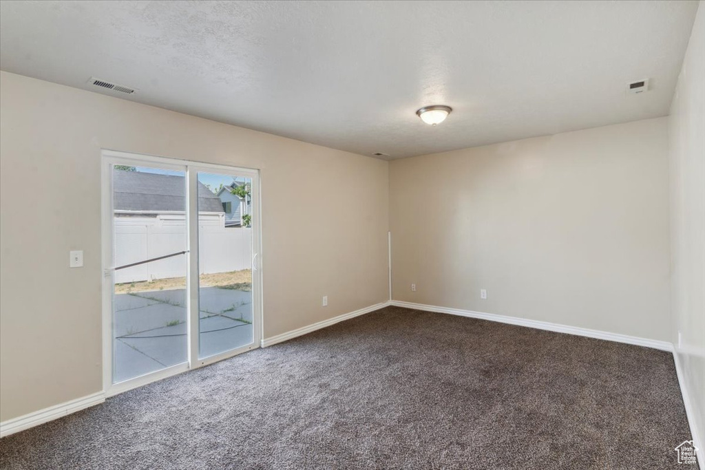 Carpeted empty room featuring baseboards