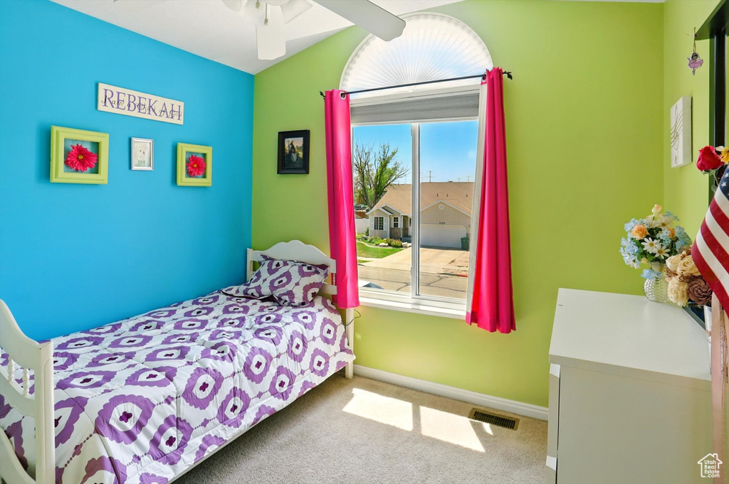 Carpeted bedroom with baseboards and vaulted ceiling