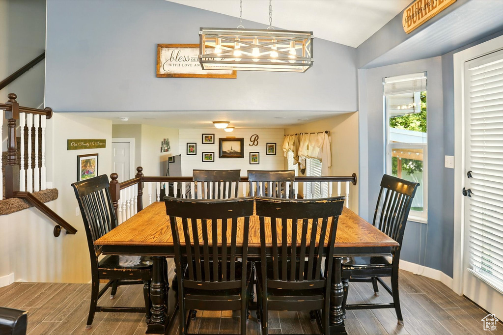 Dining room featuring wood finished floors, high vaulted ceiling, and a chandelier