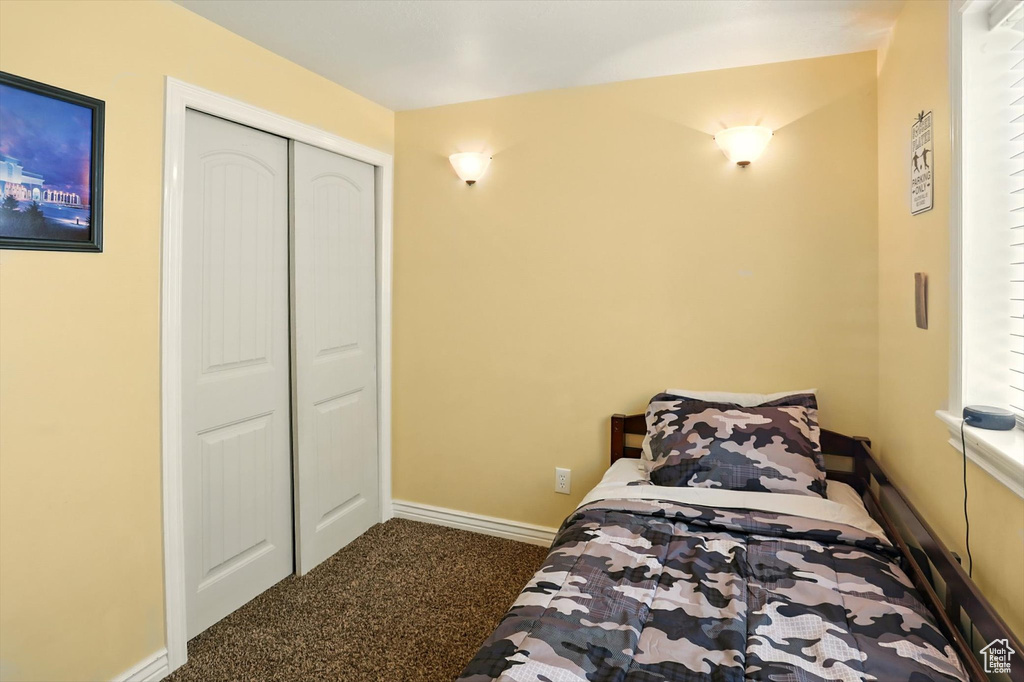 Carpeted bedroom featuring a closet and baseboards