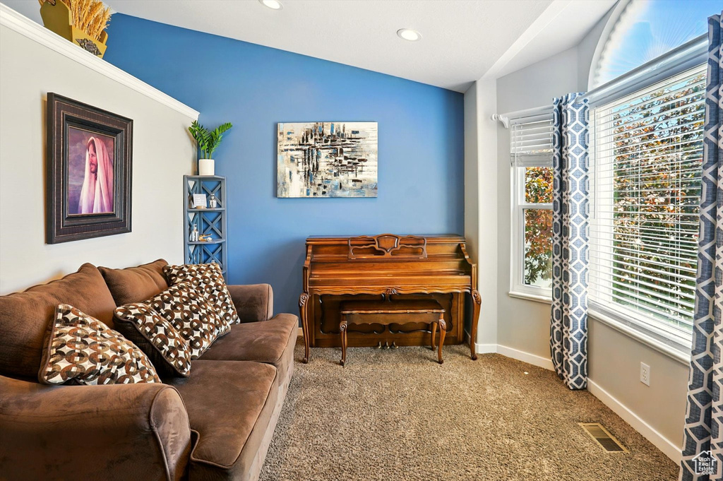 Carpeted living area featuring vaulted ceiling and recessed lighting
