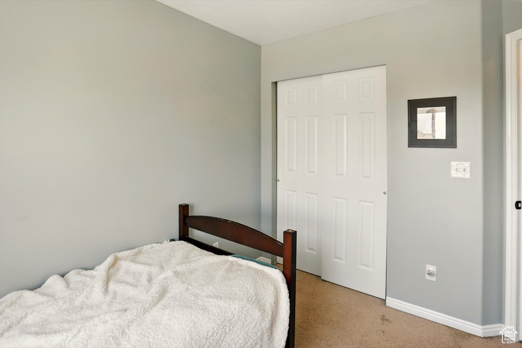 Bedroom featuring light carpet and a closet