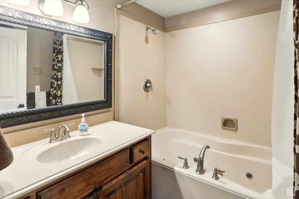 Full bathroom with vanity and a combined bath / shower with jetted tub