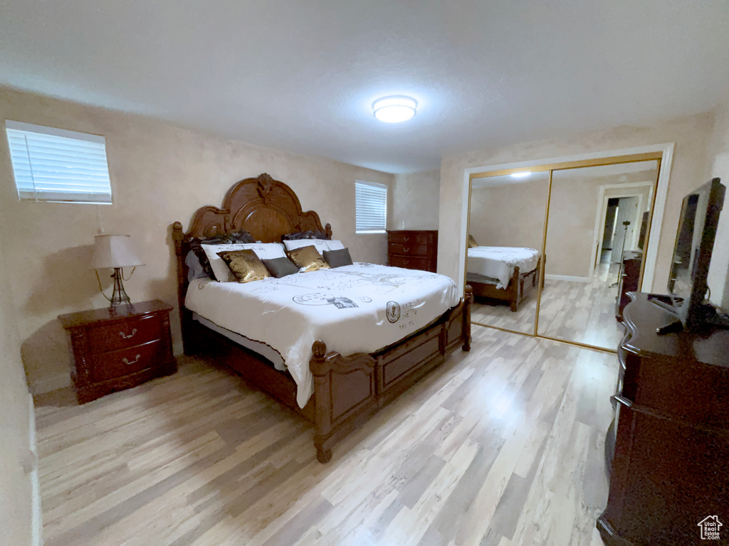 Bedroom featuring light wood finished floors and a closet
