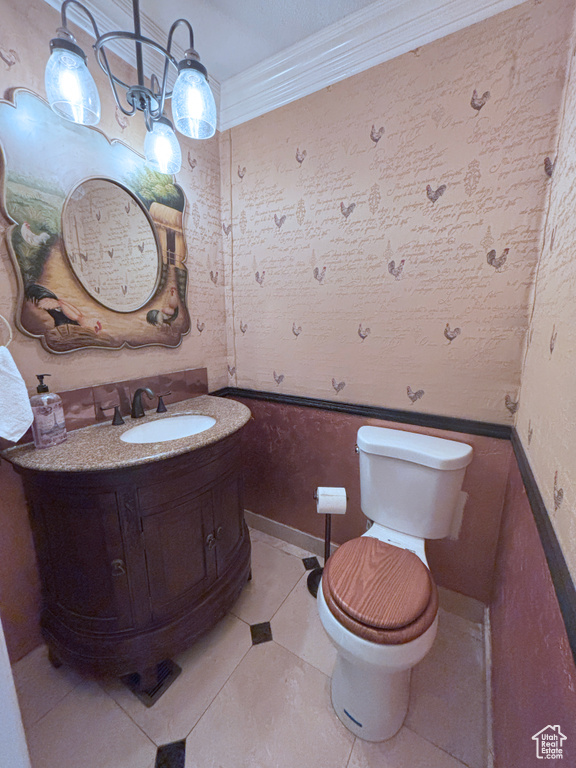 Half bath featuring vanity, crown molding, tile patterned floors, and wallpapered walls