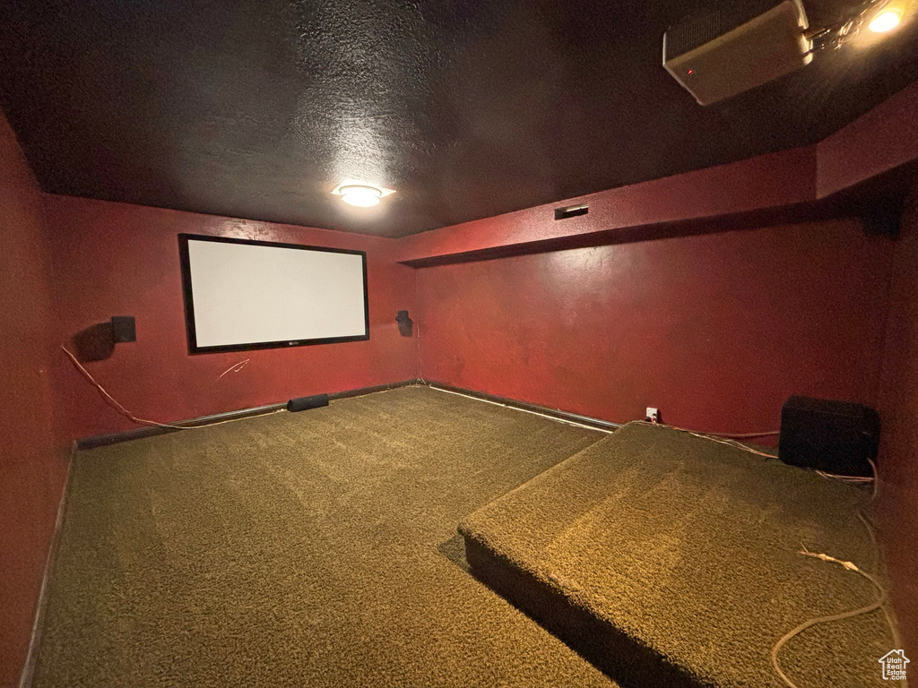 Home theater featuring carpet and a textured ceiling