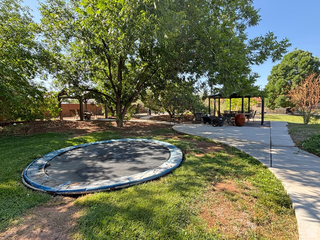 View of green lawn featuring a gazebo and a trampoline