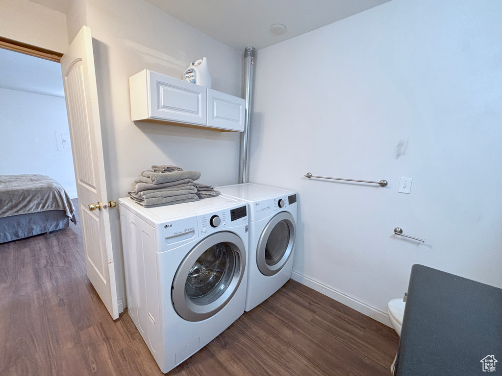 Laundry area with washing machine and dryer and wood finished floors