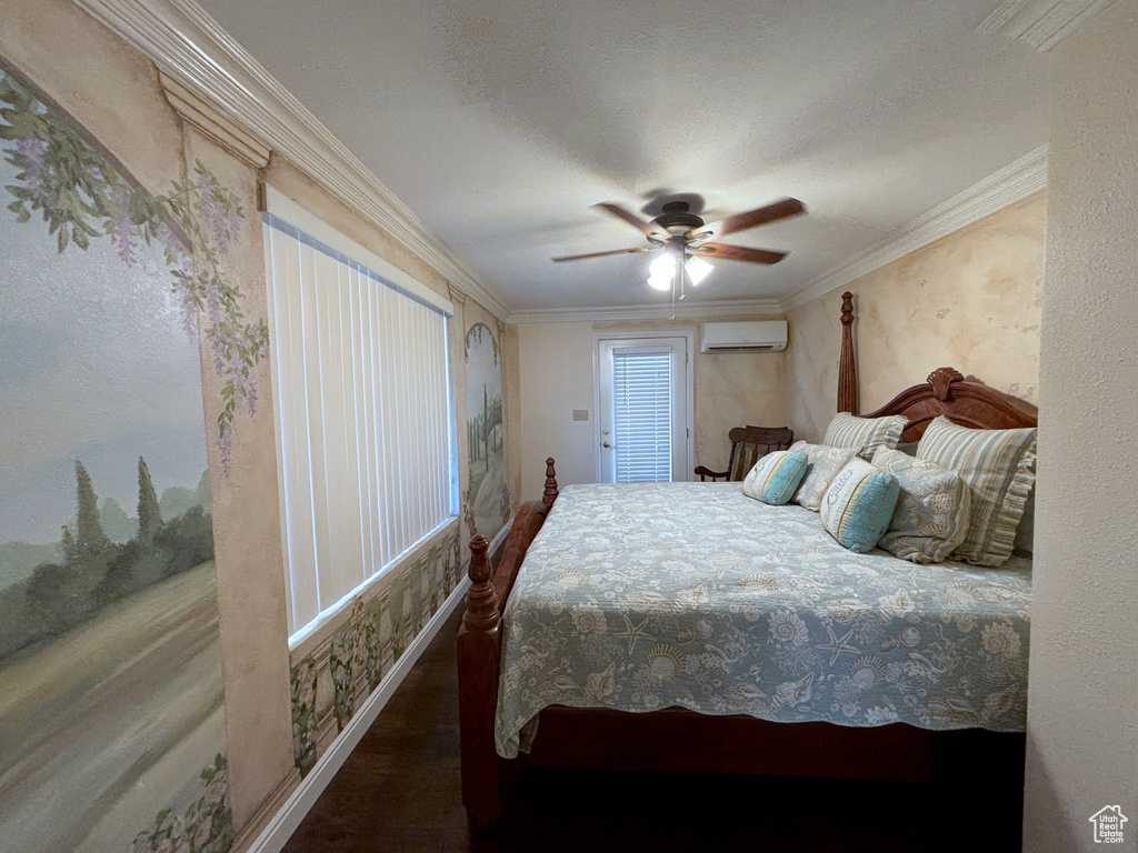 Bedroom with a wall mounted AC, ornamental molding, ceiling fan, and wood finished floors