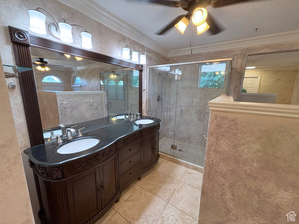 Full bathroom with a ceiling fan, double vanity, a stall shower, tile patterned flooring, and crown molding