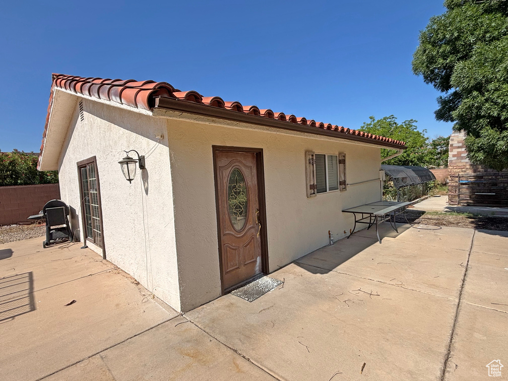Entrance to property featuring a patio area, stucco siding, and a tiled roof