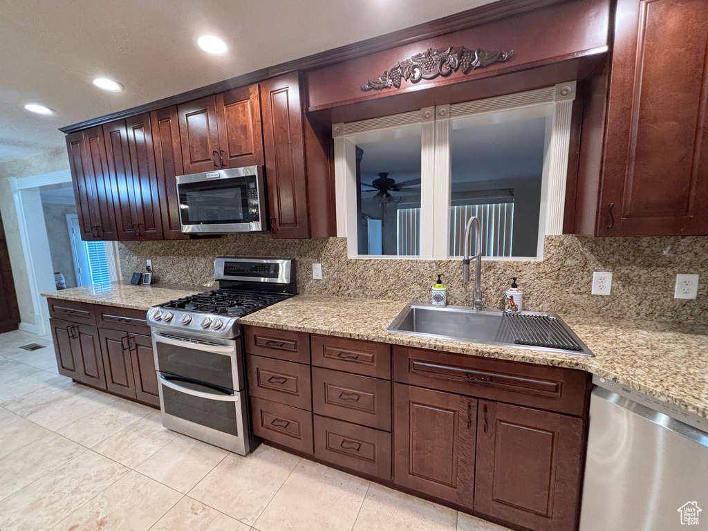 Kitchen with appliances with stainless steel finishes, backsplash, light tile patterned floors, ceiling fan, and recessed lighting
