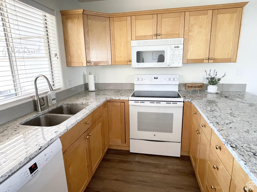 Kitchen featuring white appliances, dark wood finished floors, and light stone counters