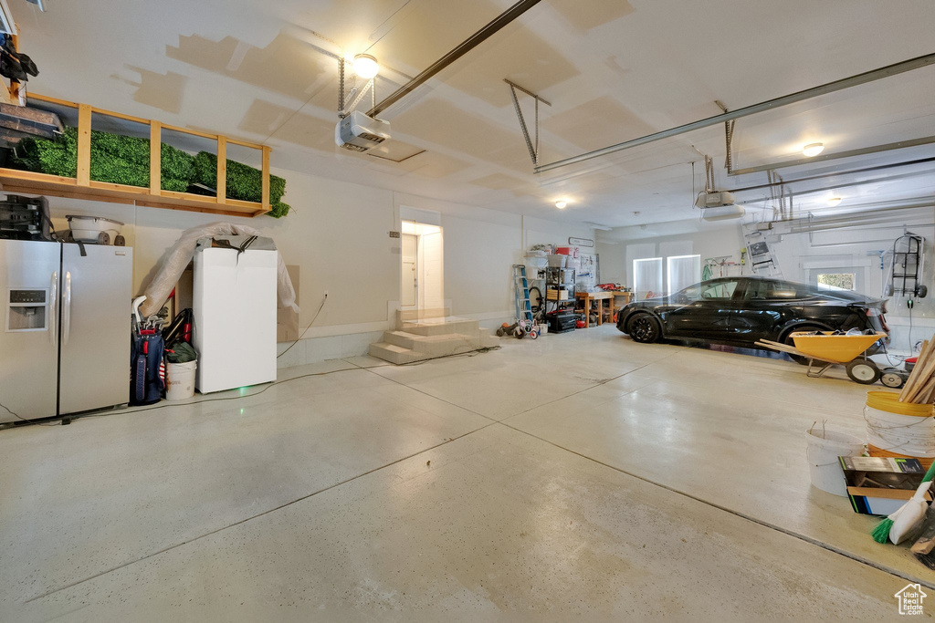 Garage with refrigerator with ice dispenser and a garage door opener