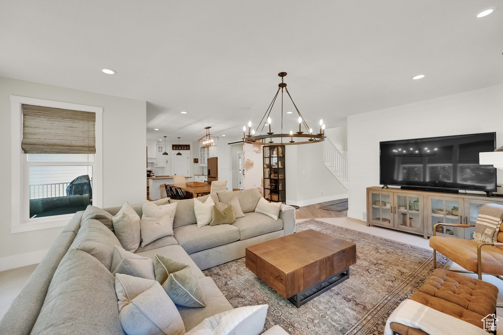 Living room with recessed lighting, stairway, and a chandelier