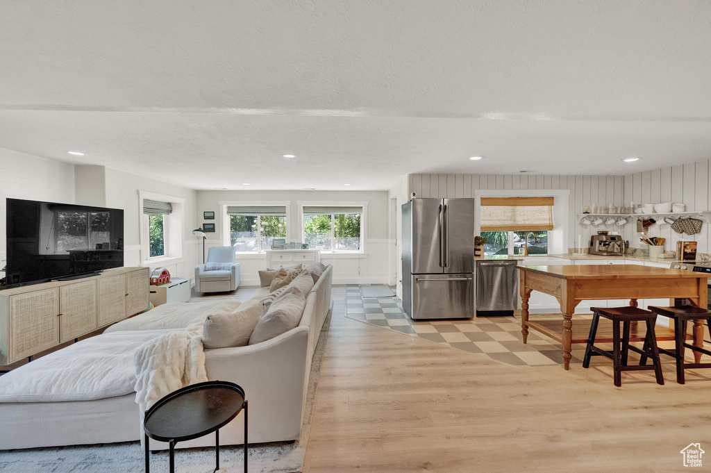 Living area with light wood finished floors and recessed lighting