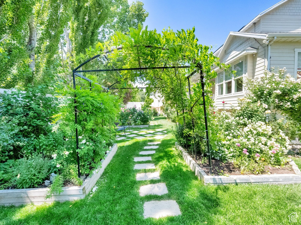 View of grassy yard featuring a garden