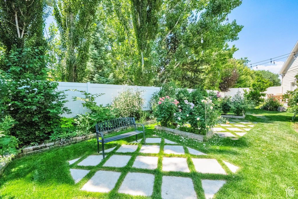 Fenced backyard featuring a garden and a patio