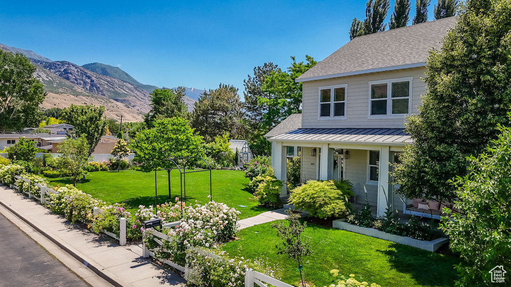 View of yard featuring a vegetable garden, a mountain view, and a porch