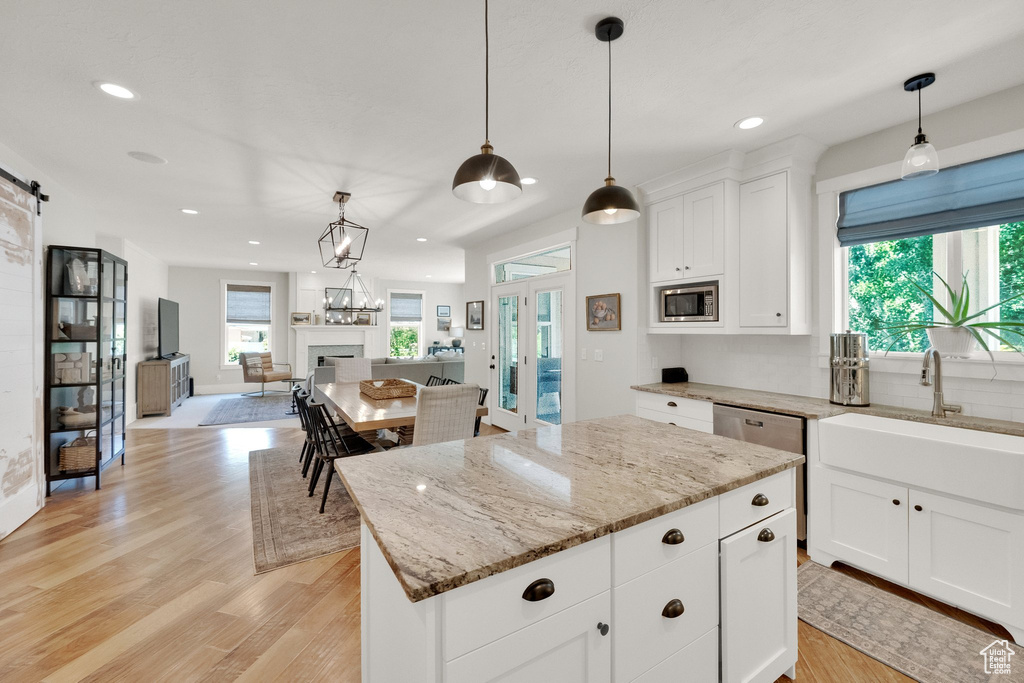 Kitchen featuring stainless steel appliances, a barn door, recessed lighting, open floor plan, and a center island