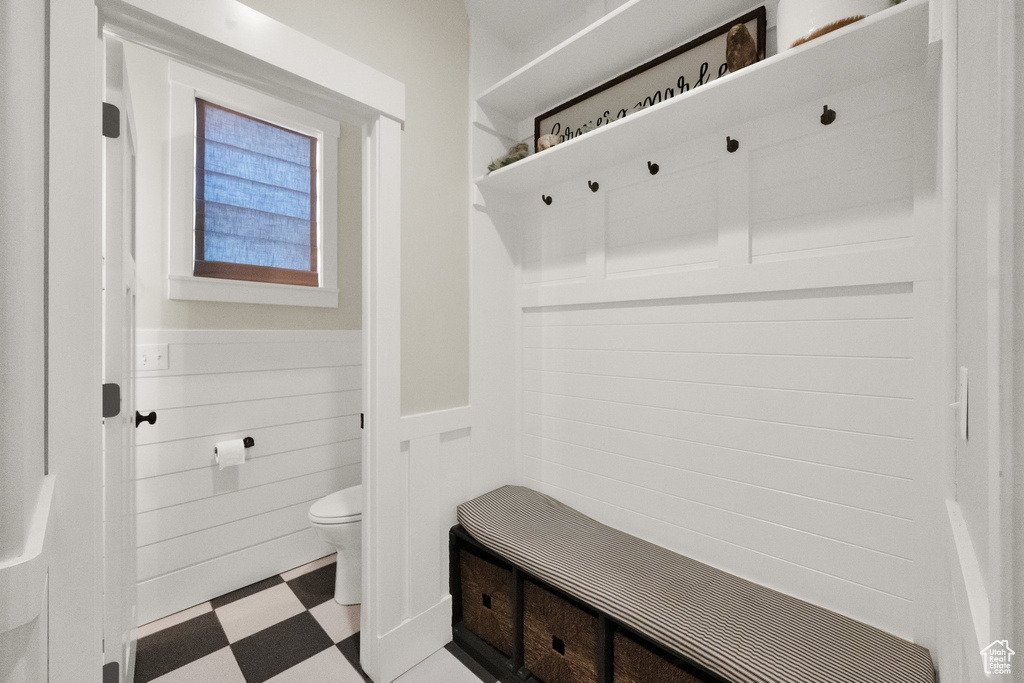 Mudroom featuring tile patterned floors and wainscoting