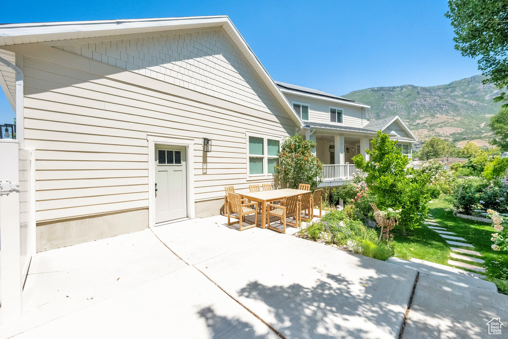 Rear view of house featuring a mountain view, outdoor dining area, and a patio area