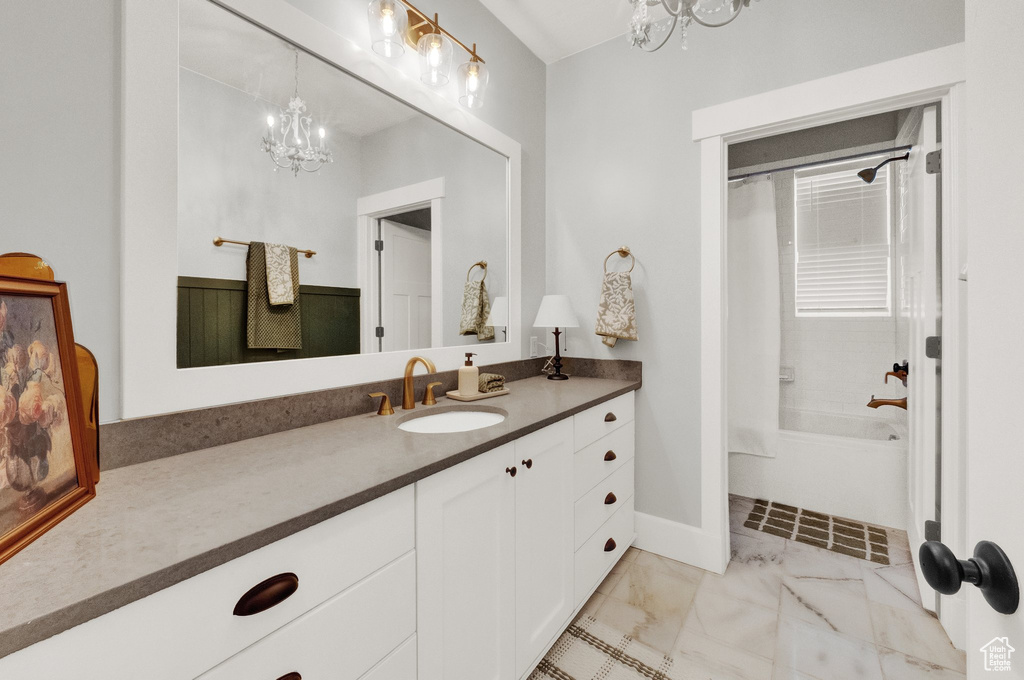 Bathroom featuring a chandelier, vanity, shower / bath combination, and marble finish flooring